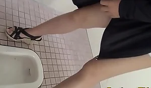 Squatting asians urinate in public toilet